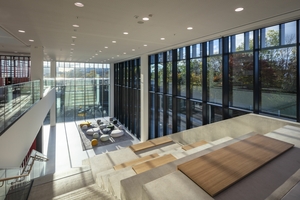  Besucher des Hilti Innovationszentrums werden im lichtdurchfluteten Foyer mit einer Loungezone und einer Freitreppe mit Sitzgelegenheiten empfangen, die bis ins Ober­geschoß reicht. 
